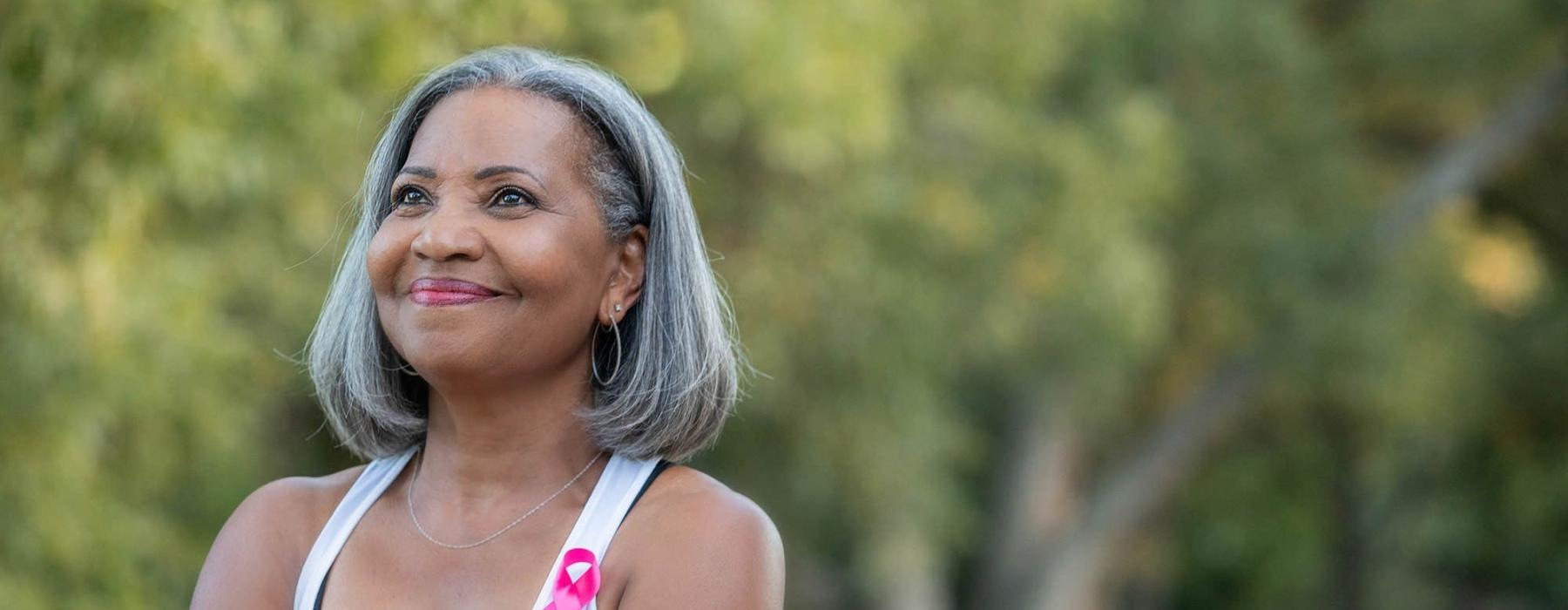 a woman with grey hair smiles to herself in neighborhood park